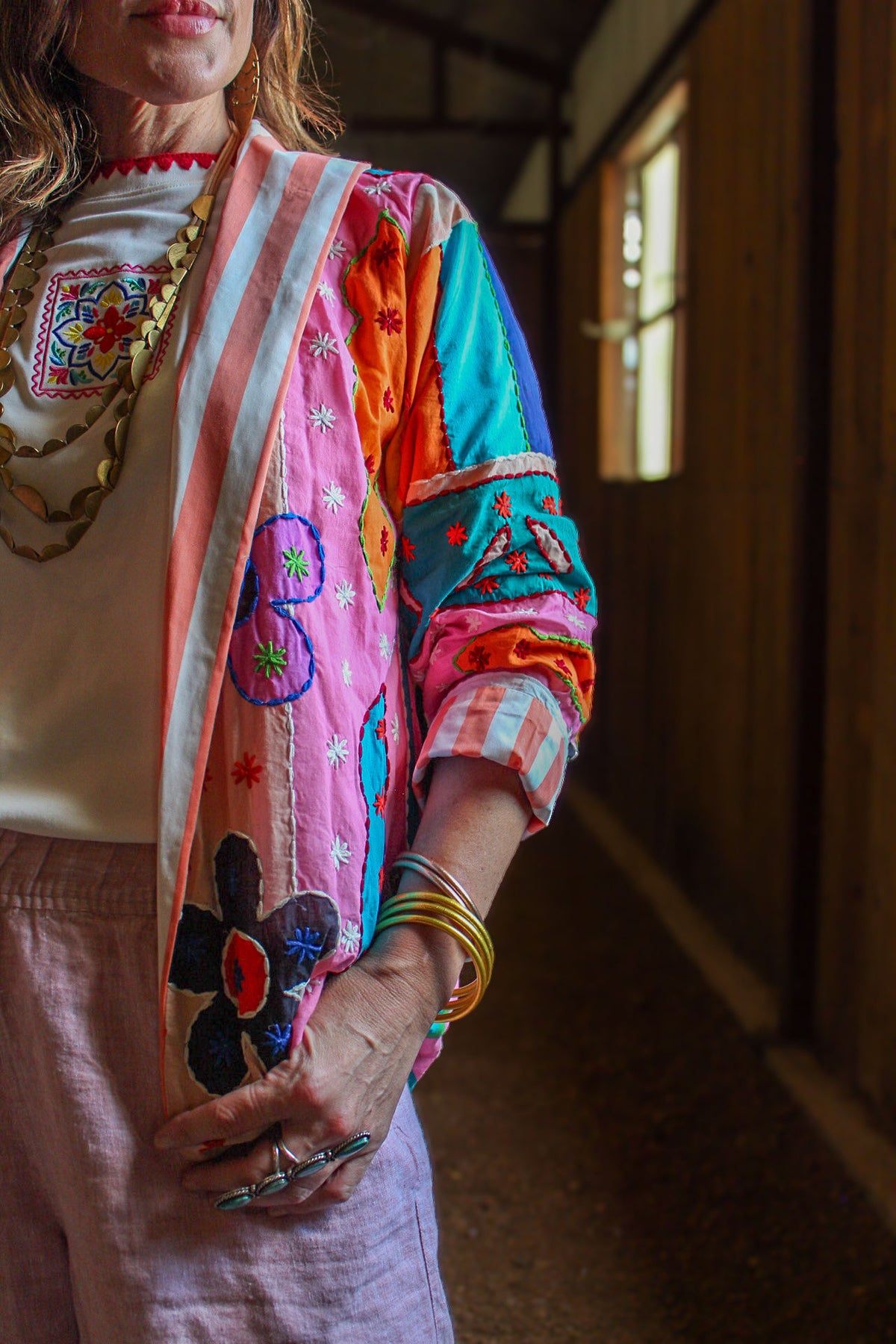 Close-up of hand-embroidered appliqué flowers and coral stripe lining on The Tracie Jacket, a western boutique patchwork jacket for fall